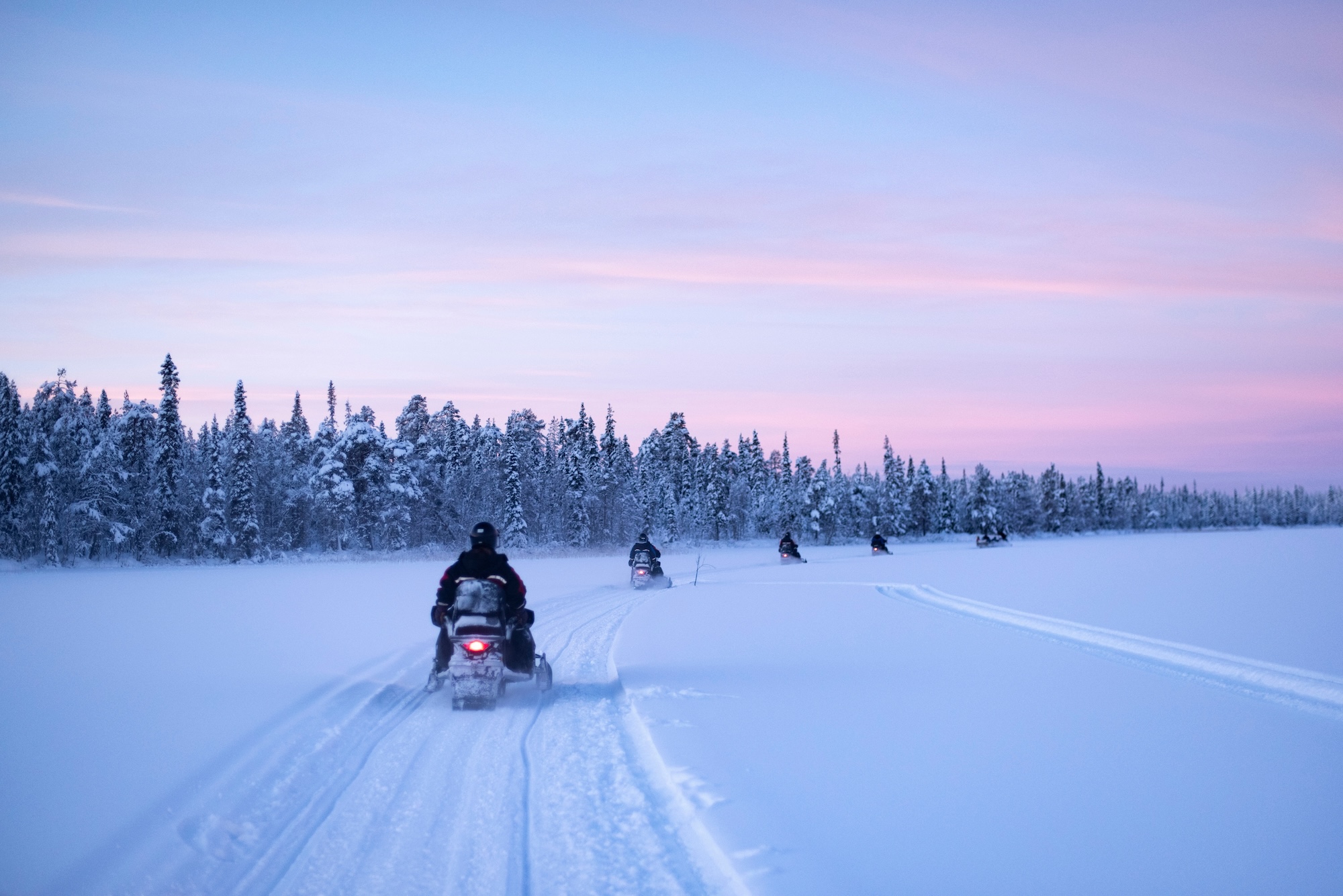 snowmobilingonthefrozenlakeatsunsetattorassieppilapland