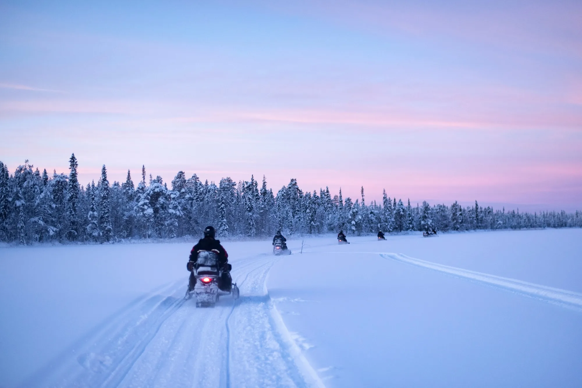 snowmobilingonthefrozenlakeatsunsetattorassieppilapland